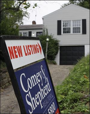 A real estate sign is posted outside a home for sale in Cincinnati.