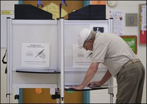 Bedford Township resident Carl Mock votes on two school funding issues Tuesday, at St. Luke's Lutheran Church in Temperance, Michigan.