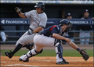 Scranton's Cole Garner scores while catcher Bryan Holaday gets the ball late during game at Fifth Third Field in Toledo, Ohio.