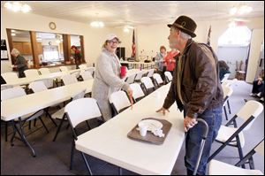 Tia Benson-Palm, assistant director of the Friends and Neighbors food pantry, speaks with diner Michael Kubach, who took advantage of the free daily meal at the building in Lottridge, Ohio.