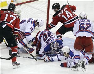 The Devils' Adam Henrique (14) scores on Rangers goalie Henrik Lundqvist just 63 seconds into overtime of Game 6.