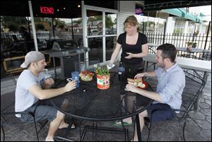 Maria Zimmerman serves lunch for Kevan Toney and Mike Richardson of Toledo at Caper's Restaurant & Bar. 