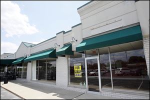 Caper's Restaurant & Bar sits between empty storefronts in a South Toledo strip mall. Owner Sue Meadows says she has watched neighbors go. She leads a business association that aims to revive patronage. 