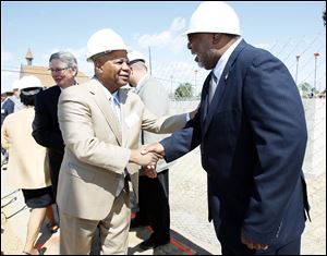 Toledo City Councilman Phil Copeland, left, greets Douglas Shelby, field director of the U.S. Department of Housing and Urban Development's Cleveland office, at the groundbreaking of Collingwood Green.