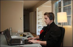 Eric Simons, 20, works in the living room of his rental cottage in Palo Alto, Calif., which he now can afford after earning the admiration of investors. He secretly camped out in AOL's offices for two months while starting his own company, ClassConnect.