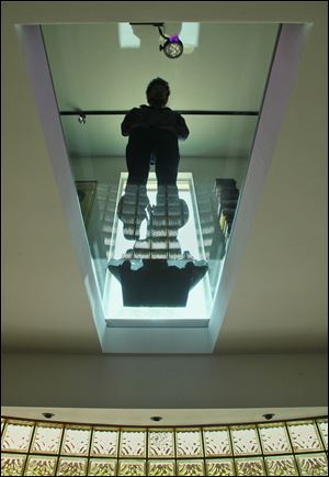 Interior designer Steve Levey stands on the structural glass floor he used in a west Akron residence. 