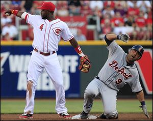 Cincinnati Reds second baseman Brandon Phillips (4) points at shortstop Zack Cozart after forcing out Detroit Tigers' Gerald Laird (9) at second base in the third inning of a baseball game, Friday.