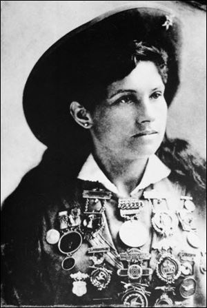 Annie Oakley, American sharpshooter and performer, is shown with a display of medals in this undated photo at an unknown location.