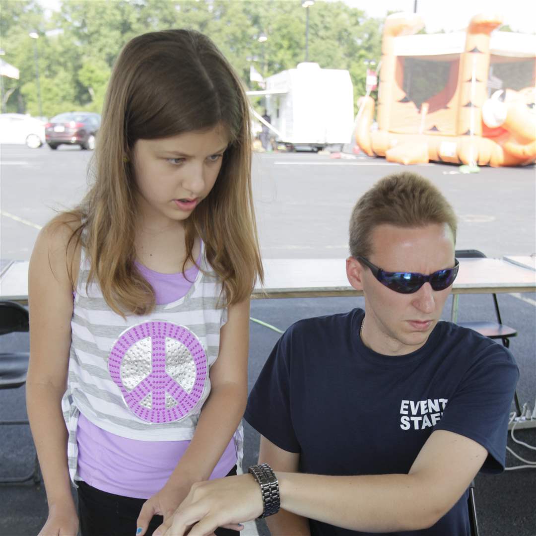 Anna-Birdsell-10-of-Toledo-left-is-fingerprinted-by-Tyler-Wepler