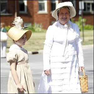 Gillian Draft, 9, and Jeanne Micka dress in period costume for the fife and drum muster, which began Saturday with a parade.  