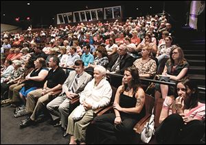 The audience listens as Michigan Governor Rick Snyder answers questions submitted by them, during a public hall town meeting.