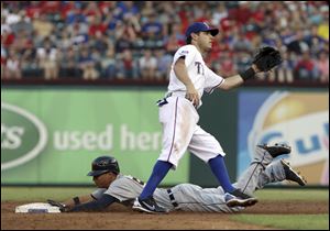 Detroit Tigers' Quintin Berry (52) steals second as Texas Rangers second baseman Ian Kinsler waits for the throw in the second inning of a baseball game in Arlington, Texas.