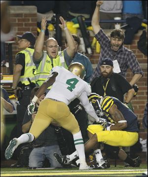 Michigan's Roy Roundtree hauls in the game-winning touchdown catch last season in front of Notre Dame's Gary Gray at Michigan Stadium. The two schools will take a break from their rivalry. UM leads the series 22-14-1.