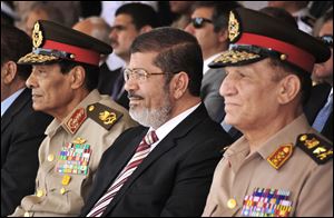 Egyptian President Mohammed Morsi, center, and Field Marshal Gen. Hussein Tantawi, left, attend a medal ceremony recently in Cairo. Morsi challenged the nation's military leaders Sunday by calling for Parliament to reconvene, weeks after a high court ordered the legislature to dissolve because of fears that Islamists would dominate the government.