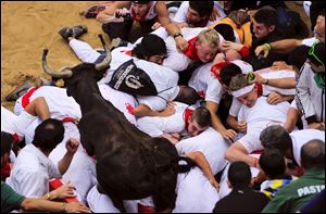 A cow jumps over revelers on the bull ring, at the end of third running of the bulls at the San Fermin fiestas, in Pamplona northern Spain, Monday.