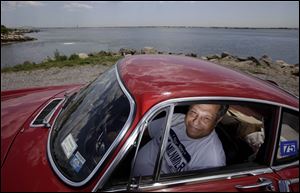 Irv Gordon poses for a picture in his Volvo P1800 in Babylon, N.Y. Gordon's car already holds the world record for the highest recorded milage on a car and he is less than 40,000 miles away from passing three million miles on the Volvo,