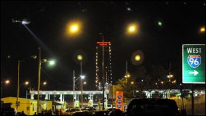 A helicopter flies overhead with its spotlight on over the Ambassador Bridge between Detroit and Windsor, Ontario after it was closed down by a bomb threat Monday