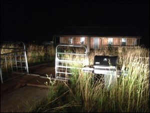 Lights from law enforcement vehicles illuminate the cabin near Sistersville, W.Va., where Sylvania fugitive Thomas Jack Fritz, 38, was found dead of a single gunshot wound late Tuesday.