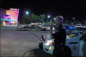 An Aurora Police officer talks on his radio outside of the Century 16 theater at Aurora Mall where as many as 14 people were killed and many injured at a shooting at the Century 16 movie theatre in Aurora, Colo., Friday.