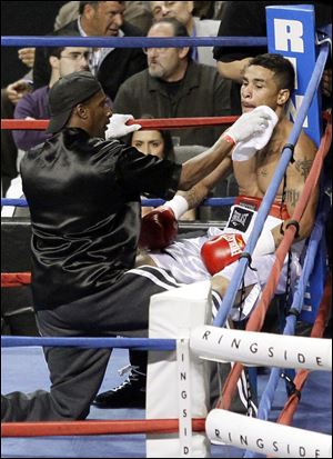 Boxer Martin Tucker is tended to during a match at the Huntington Center on April 28. The FBI said it obtained a discarded swab that was used to stop his bleeding to get his DNA as part of an investigation.