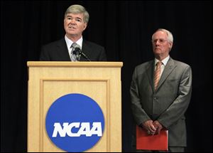 NCAA President Mark Emmert, left, announces penalties against Penn State  as Ed Ray, NCAA Executive Committee chair and Oregon State University president, looks on at right, during a news conference in Indianapolis.