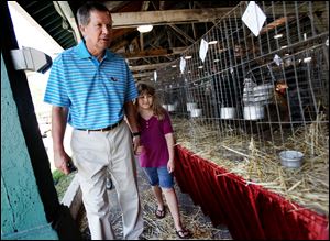 Gov. John Kasich tours the rabbit and poultry barn with Cameron Corcoran, 8, of Chillicothe at the Ohio State Fair on Wednesday. Mr. Kasich pushed for federal aid for Ohio's drought-stricken farmers after touring the fair.