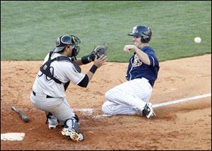 Louisville catcher Dioner Navarro awaits the throw as he prepares to tag out the Hens' Danny Dorn in the eighth inning. Toledo dropped its fifth straight game and now has the worst record in the league.