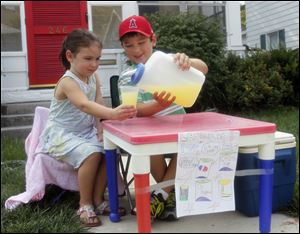 4-year-old daughter Penelope McClough and her brother Oliver, 8, sell lemonade in Bowling Green. Certain that their children are kindergarten ready, parents of children held back by school district birthday deadlines are challenging the system and a few of them are winning.