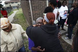 Naomi Reed, center, is comforted after a prayer for her granddaughters, Keondra, 1, and Leondra, 2. More than 50 people turned out for the vigil for the girls Saturday and to comfort her relatives.