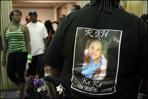 A mourner wears a photo of Keondra Hooks. Among the dozens of mourners was Toledo Mayor Mike Bell. Keondra's sister, Leondra Hooks, 2, was wounded but improving.