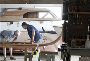 Jeff Martin, left, and Dave Riddle work on the keel of the replica. The crew hopes to finish the boat by Aug. 30.