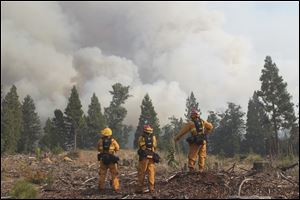 Firefighters keep a safe distance while they monitor the Ponderosa fire near Viola, Calif. That blaze threatened 3,500 homes in northern California about 170 miles north of Sacramento.