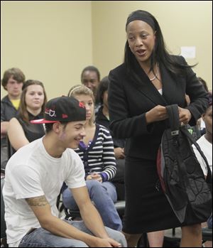 Tamara Williams, associate vice provost at Owens, Monday uses the backpack of Trey McBrayer, 17, as a prop as she advises students to put their dreams in their bags and carry them with them every day.