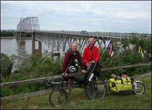 Bowling Green friends Russ Frye, left, and Tom Vanden Eynden take a break during their 4,300-mile bicycle trek with the Mississippi River in the background.