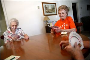 Myra Lucky, left, and Jean Ladd, 90, both of Woodville, Ohio, play their monthly game of pinochle with their two friends Louis Grove and Fran Greenley at Ladd's home Wednesday, Aug. 22, 2012.  Ladd is one of two surviving members of the card club that started 65 years ago.  