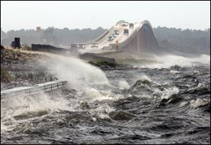 Waves from the Santa Rosa Sound crash over the Navarre Beach causeway in Navarre, Fla., as Isaac approaches. Gusts of 100 mph were expected along the Gulf.