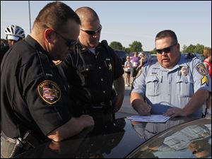 Wood County Sheriff deputies Jamie Webb and Chris Klewer coordinate with Perrysburg Police Sgt. Brian Gregg during an event this summer in Perrysburg.