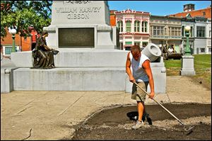 Dan Koerper of Mohawk Nursery prepares topsoil near the statue of Gen. William Harvey Gibson. He was part of a four-men crew who worked Thursday. Underground irrigation is to be completed today.