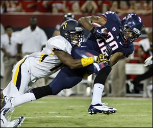 Arizona's Austin Hill (29) tries to break the tackle of Toledo's Cheatham Norrils, left, during the first half of an NCAA college football game at Arizona Stadium in Tucson, Ariz.