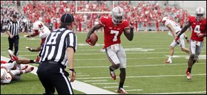 Ohio State CB Travis Howard (7) runs up the sidelines after an making an interception against Miami during the fourth quarter.