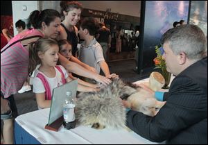 Visitors meet wolf fur, a polar bear foot, and Jeff Sailer. From left are Elena Gojcaj, Maria Gojcevic, Olivia Gojcaj, and Amanda and Antonio Sagar, all of Macomb Township, Michigan.