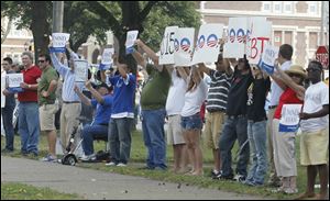 Supporters of Republican presidential candidate Mitt Romney greet President Obama as he arrives at Scott High School.