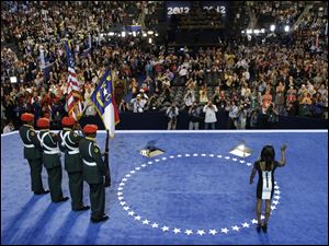 Olympic gold medalist Gabby Douglas waves to candidates after reciting the Pledge of Allegiance at the Democratic National Convention in Charlotte, N.C.