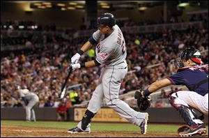 Cleveland Indians' Michael Brantley (23) hits an RBI-single against Minnesota Twins relief pitcher Alex Burnett as Twins' Joe Mauer, right, watches during the seventh inning Friday night.