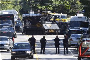 A police armored vehicle advances toward the house in West Bloomfield Township in which the officer died. 