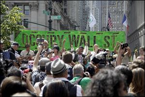 People listen to an Occupy Wall Street anniversary concert in Foley Square in New York on Sunday. The movement will mark its first anniversary on Monday.