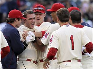 Cleveland’s Lonnie Chisenhall, second from left, is mobbed by teammates after his game-winning single