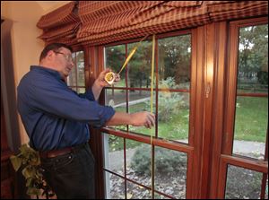 Mike Marchant of Arnold's Home improvement measures a window at the Sylvania Township home of Larry and Sharon Roan. The Roans had vinyl windows and a french door installed.