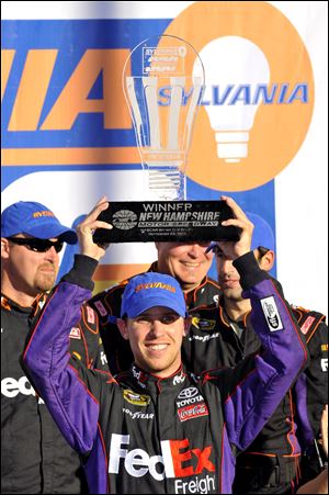 Denny Hamlin celebrates his win in victory lane at the NASCAR Sprint Cup Series auto race at New Hampshire Motor Speedway, Sunday.