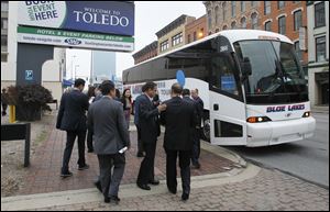 Local and Chinese business leaders board waiting buses for a tour of the region as part of the 5 Lakes Global Economic Forum.